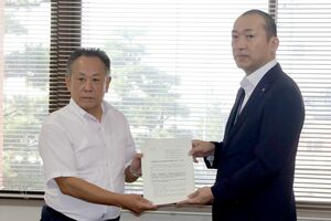 新発田市教育委員会で申し入れ書を手渡す「新潟県(新発田市)に夜間中学校の設置を求める会」の久志田実さん(左)=10月1日、新発田市乙次