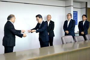 米田徹糸魚川市長(左)に財政支援などの緊急要望書を手渡した山岸文範院長(左から2人目)=8月14日、糸魚川市役所