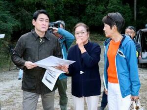 メガソーラーの工事現場付近を訪れ、市民団体のメンバーから説明を受ける野口健さん(左)=30日午後、千葉県鴨川市