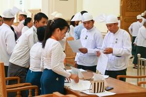 　１６日、ミャンマーの首都ネピドーの下院に登院し手続きする議員ら（共同）