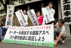 建設現場のアスベストを巡る訴訟で和解が成立し、横断幕を掲げる原告と弁護団=7日午後、東京・霞が関