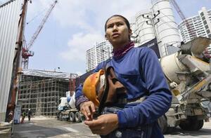 　建設中のビル工事現場から出てきたアイアイアウン。ヘルメットを脱ぐと、顔には疲れが色濃く浮かんでいた＝２０２６年２月、バンコク（撮影・浮ケ谷泰、共同）