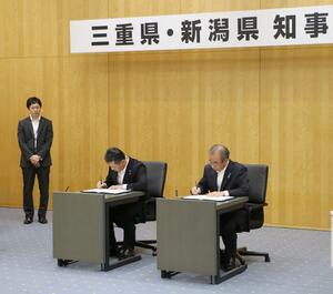 災害時の相互応援協定を結んだ花角英世知事(右)と三重県の一見勝之知事=9月12日、新潟市中央区