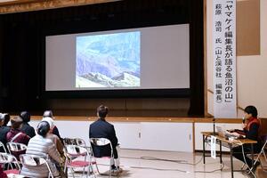 スライドを使って魚沼市内にある山の魅力を語る萩原浩司さん(右)=魚沼市堀之内公民館