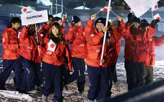 ミラノ・コルティナ冬季五輪の開会式で、旗手の冨田せな（右手前）を先頭に入場する日本選手団。プラカードを持っているのは工藤璃星＝６日、イタリア・リビーニョ（代表撮影・共同）