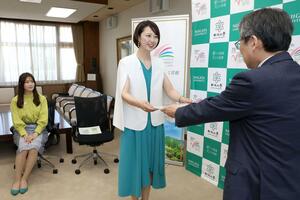 牛木辰男学長から任命状を受け取る、宇賀神唯さん(中央)と山田彩乃さん=新潟市西区五十嵐2の町