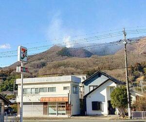 群馬県桐生市の山林火災で、山中から立ち上る白煙=11日午後(近隣住民提供)