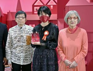 「角野栄子あたらしい童話大賞」に選ばれ、審査委員長の角野栄子さん(右)、特別審査員の原ゆたかさん(左)と写真に納まる迂回ひなたさん=11月26日、東京都江戸川区