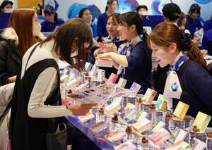 バレンタイン催事「アムール・デュ・ショコラ」の先行販売で品定めをする買い物客(左)=15日午後、名古屋市のジェイアール名古屋高島屋