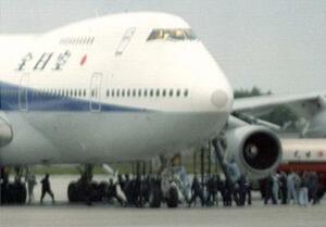 1995年6月、ハイジャックされた全日空機にはしごをかけ、機内に突入する捜査員ら=函館空港