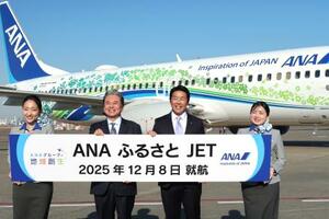 羽田―鳥取間で就航した特別デザイン機「ANAふるさとJET」の前で撮影に応じる関係者ら=8日午後、羽田空港