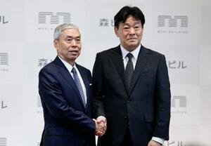 　森ビル社長交代の記者会見を終え、握手する辻慎吾社長（左）と向後康弘氏＝２０日午後、東京都港区