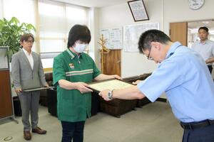 ロマンス詐欺被害を防いだとして、感謝状を贈られた安澤敬子さん(中央)と若杉正和さん(左)=新潟江南署