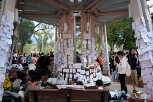 火災が起きた高層住宅群近くの公園に張られた市民の追悼メッセージ=7日、香港(共同)