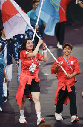 パリ五輪の閉会式で、日の丸を手に入場する旗手の北口榛花（左）と半井重幸＝８月１１日、パリ郊外（共同）