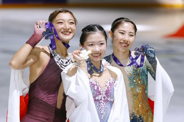 グランプリシリーズ初出場優勝を果たした中井亜美。左は２位の坂本花織、右は３位の住吉りをん＝アンジェ（共同）