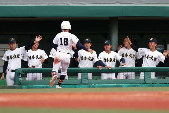 敦賀気比－日本文理　５回日本文理２死二、三塁、渡部倖成が適時打を放ち３－１。３走神田祈玖を迎え入れる日本文理ベンチ＝富山市民球場