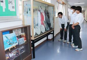 セーリング男子パリ五輪代表の富澤慎選手の展示を見る柏崎工業高校の生徒=柏崎市栄町