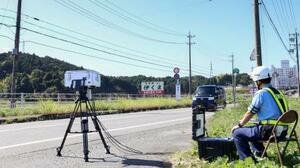 事故現場付近で速度違反車を監視する警察官=9日午前、三重県名張市