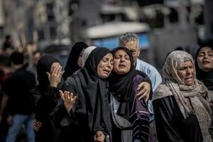 6月、ガザ北部ガザ市で、イスラエルの攻撃による親族の死を嘆く人々(ゲッティ=共同)