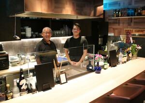 店先に立つオーナーの吉田忠廣さん(左)と店長の風間涼さん=新発田市中央町3