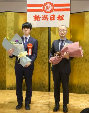 棋王戦の開会式で互いに健闘を誓う渡辺明棋王(右)と藤井聡太五冠=3月4日、新潟市中央区