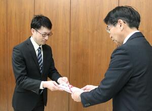 長岡工業高の諸橋孝二校長(右)に目録を手渡す古川機工の古川琢也社長=長岡市幸町2