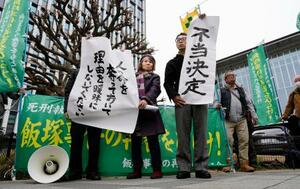 　「飯塚事件」の再審開始が認められず、福岡高裁前で「不当決定」などと書かれた紙を掲げる支援者ら＝１６日午後