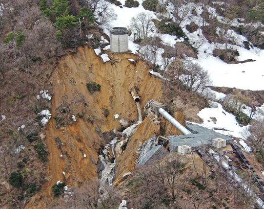 破断した水管（中央）と土砂崩れ現場。右下は倒壊した鉄塔＝６日、上越市（県提供）