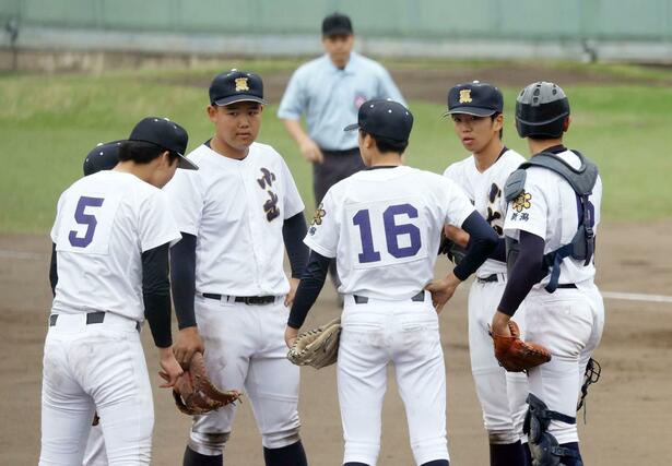 ６回裏柏崎１死一、三塁のピンチで豊野暖（右から２人目）の周りへ集まる小出の内野陣＝４月２８日、柏崎市佐藤池野球場