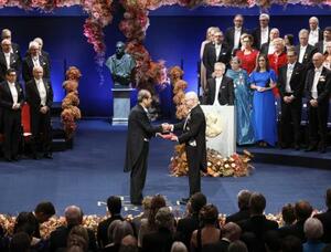 　ノーベル賞授賞式で、化学賞のメダルと賞状を授与される北川進・京都大特別教授（左）＝ストックホルム（共同）