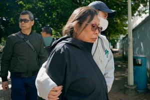 犠牲者の身元確認を行う写真の保管場所から出てきた女性=28日、香港北部・新界地区大埔(共同)