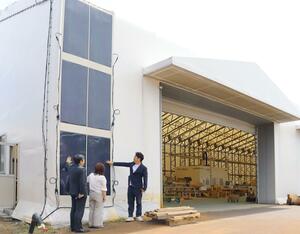 製材所のテント壁面で発電する次世代太陽電池「カルコパイライト」。実証事業の関係企業は新潟県など積雪地でも導入拡大につながると期待する＝阿賀野市