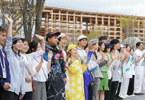 4月、大阪・関西万博が開幕し来場者を迎えるスタッフら=大阪市此花区の夢洲