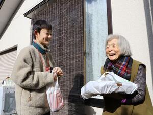 1人暮らしのお年寄りにおせち料理を届ける小須戸中の生徒=12月30日、新潟市秋葉区