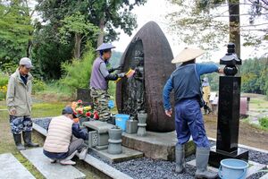 中越地震から21年となるのを前に慰霊碑を清掃した住民ら=19日、小千谷市塩谷
