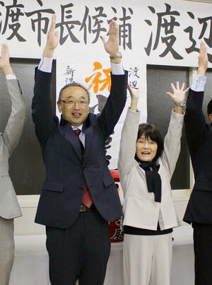 佐渡市長選で無投票での再選が決まり、万歳をする渡辺竜五氏(左)=4月7日午後6時30分過ぎ、佐渡市中原