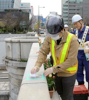 萬代橋の欄干に書かれた落書きの消去作業=4月18日、新潟市中央区