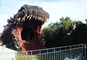 「ジップライン」でゴジラの口の中に飛び込んでいく=兵庫県淡路市