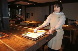 創業100年を機に再開した扇屋旅館のカフェ。スタッフがタイ料理を運ぶ=村上市田端町
