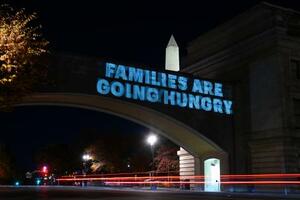 食糧支援の遅れに対して「家族が飢える」と訴える電光板=3日、ワシントン(AP=共同)