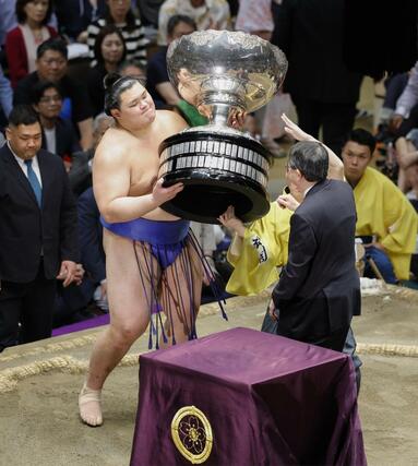 大相撲夏場所で２場所連続優勝し、日本相撲協会の八角理事長（左）から賜杯を受け取る大の里＝２５日、東京・両国国技館