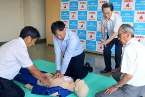 4人の迅速な連携を再現した様子。倒れた男性従業員の命に別条はなかった=新発田市新栄町1