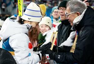 　女子個人ラージヒルを終え、母信子さんの写真に触れる丸山希。右は父守さん＝プレダッツォ（共同）