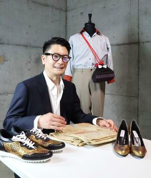 万博に出展する新作のコンセプトを語る杉浦充宜さん。後ろは「おいこっと」の制服、テーブルの上は着物の帯からリメークした靴=十日町市上野甲