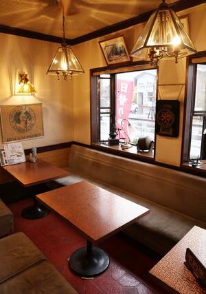 深い茶色を基調とした舎鈴夢の店内。世界中のコーヒーグッズを飾っている