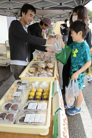 地元菓子店のスイーツを品定めする朝市の来場者=9月23日、上越市中央3