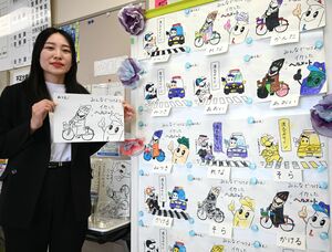 交通ルールを周知する塗り絵イラストを作成した小林千尋さん。園児が色を塗った塗り絵も掲示されている=糸魚川署
