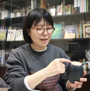 　鳥類の研究に使うエミューの卵を持つ黒岩麻里さん