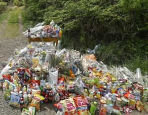 　安達結希さんの遺体が遺棄された現場付近に供えられた花や飲み物など＝２２日、京都府南丹市